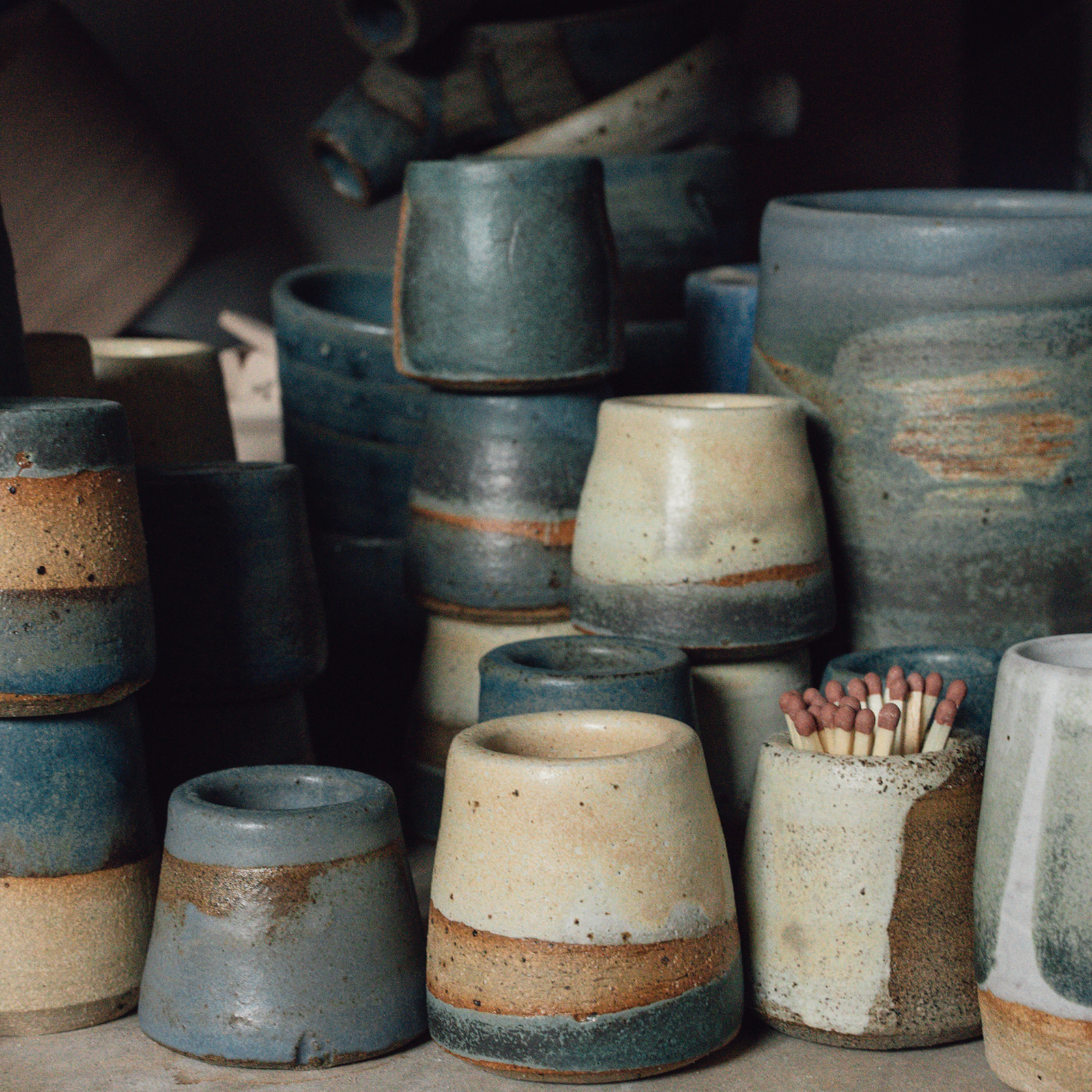 Stacks of cobalt blue, orange ochre and off white glazeware